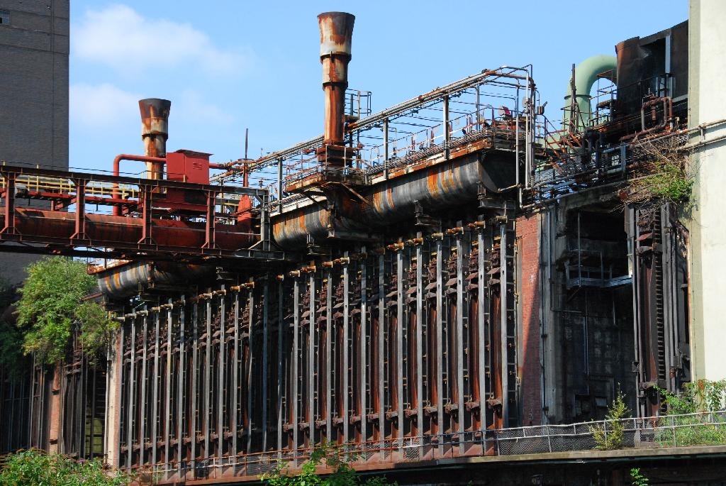 DSC_3751.JPG - [de]In insgesamt 304 dieser senkrechten Öfen wurde Kohle unter Sauerstoffabschluss bei über 1.000°C zu Koks "gebacken", der dann in Stahlwerken als hochenergetischer Brennstoff zum Schmelzen des Erzes verwendet wurde. Zum Heizen der Koksöfen wurde Gas benutzt, das vor Ort anfiel (Kokereigas) oder solches, das in den Stahlwerken entstand (Gichtgas) und von dort geliefert wurde. Durch die intelligente Weiternutzung war das Gas Teil eines ausgeklügelten Energiekreislaufs. Nebenprodukte bei der Koksherstellung waren Teer, Düngemittel oder Schwefelsäure.[en]Coke was "baked" in a total of 304 vertical ovens at 1,000°C (1,800°F). Steel works demanded this type of  high enery solid fuel to melt ore. The gas used to heat the ovens was either being generated on-site or at the steel works. Thus the gas was part of a clevery devised energy cycle. Tar, fertilizer or sulphuric acid resulted as side products of the coking process.